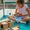 A girl playing with her hamster in the playpen with various accessories