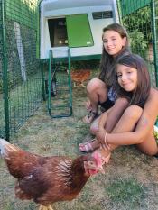 Two girls spending time with their chickens.