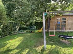 A garden with an Omlet chicken house at the back.